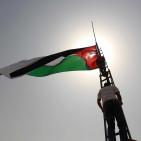 فلسطينيون يرفعون العلم الفلسطيني خلال تظاهرة ضد الاستيطان في قرية النبي صالح