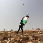 فلسطينيون يرفعون العلم الفلسطيني خلال تظاهرة ضد الاستيطان في قرية النبي صالح