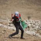 فلسطينيون يرفعون العلم الفلسطيني خلال تظاهرة ضد الاستيطان في قرية النبي صالح