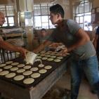 مواطنون يعملون في صناعة القطايف في مدينة رام الله