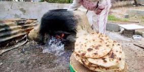 امراة فلسطينية  تخبز على الطابون في مهرجان العنب في الخليل