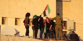 متظاهرون يعتلون احد المباني التابعة للارتباط العسكري الاسرائيلي ويرفعون الأعلام الفلسطينية