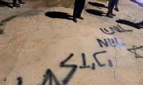 مستوطنون يحرقون مركبة ويخطون شعارات عنصرية في بلدة عطارة