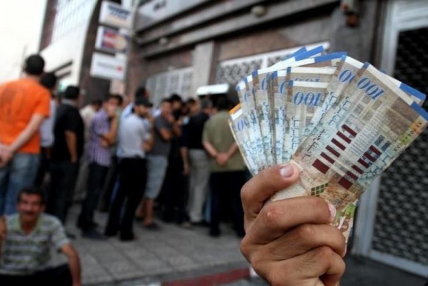 اصطفاف الموظفين لتلقي رواتبهم عبر الصراف