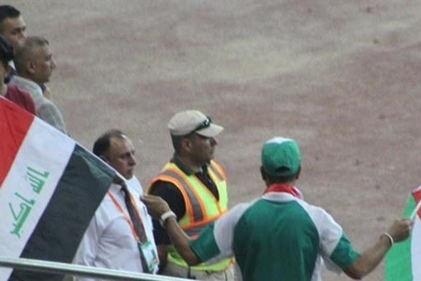 مشجع يحمل العلم العراقي والعلم الفلسطيني