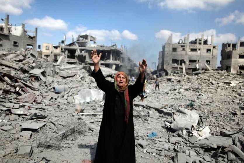 فلسطينية تقف على ركام منزلها الذي قُصفه الاحتلال