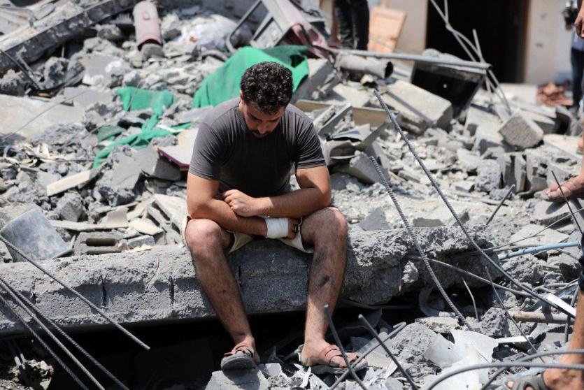 مواطن يجلس على انقاض منزله المدمر في غزة