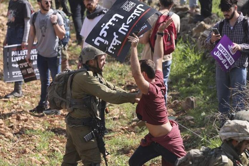 قوات الاحتلال الإسرائيلي تعتدي على أحد المشاركين في المسيرة (تصوير: أ ف ب)